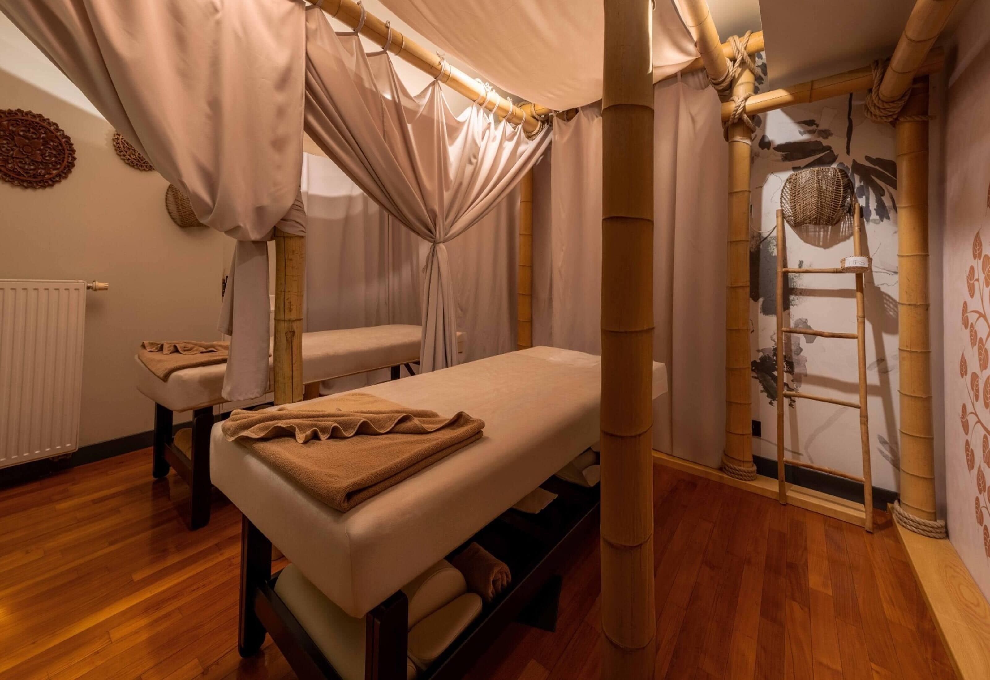Um quarto com uma cama, uma mesa de massagem e uma escada encostada na parede.