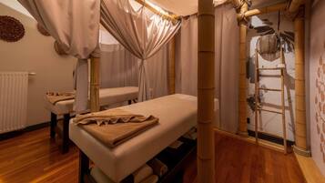 A room with a bed, a massage table, and a ladder against the wall.