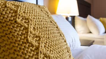 A close-up of a textured, knitted throw blanket on a bed.