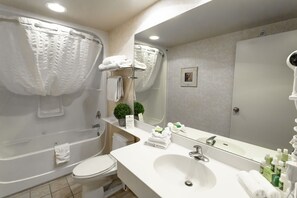Bathroom features a bathtub, toilet, sink, and mirror.