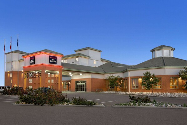 Welcome to our hotel, featuring a grand entrance with a glass door and stairs leading up to it.