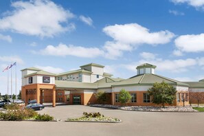 Stunning hotel with a two-story design, featuring a central tower and double entrance doors.
