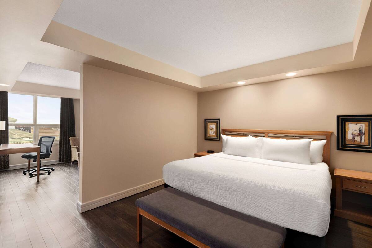 Habitació d'hotel amb un llit gran, una panxa, una taula i una cadira.