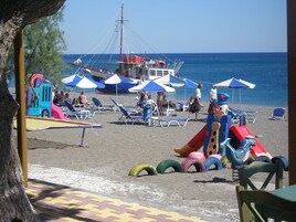 Una playa cerca, sillas reclinables de playa, sombrillas