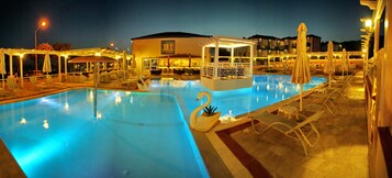 Una piscina al aire libre de temporada, sombrillas