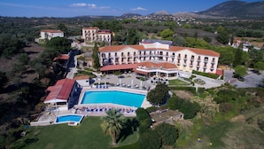 Un hotel grande con varias edificaciones, piscina y vegetación circundante.