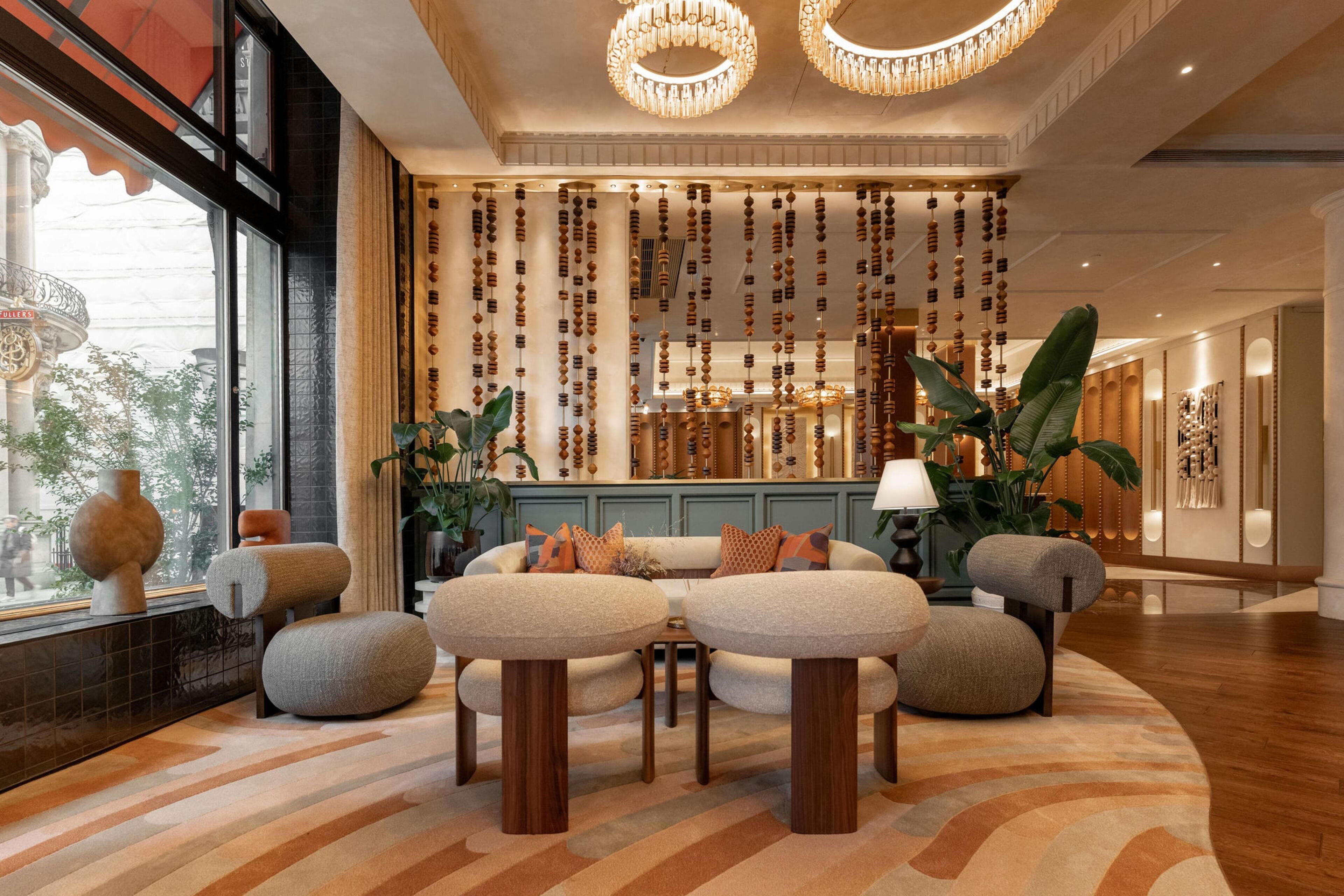 A modern lobby with a seating area, a decorative wall, and a large window.