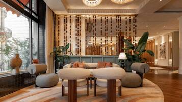 A modern lobby with a seating area, a decorative wall, and a large window.