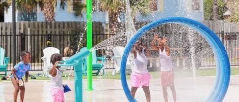 A water play area with a circular water feature and a green pole.