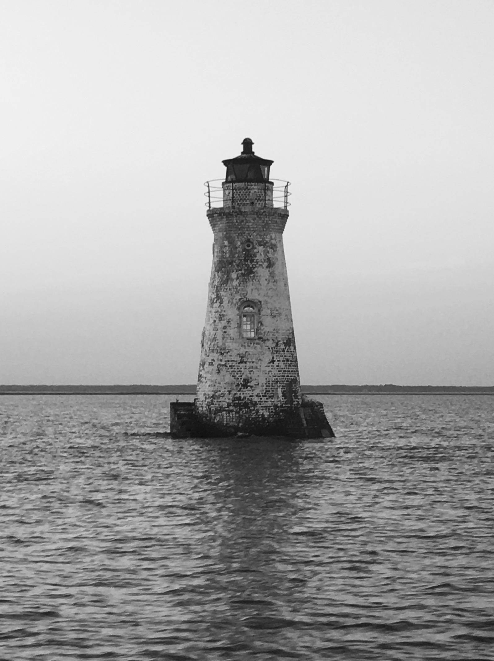 Un faro se alza en el agua, con una vista despejada del horizonte.