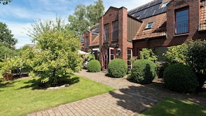 A brick building with a restaurant sign, solar panels, and well-maintained gardens. - Hotel ARTE Schwerin (Schwerin)