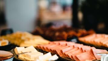 A buffet with various food items including sliced meats and cheeses.