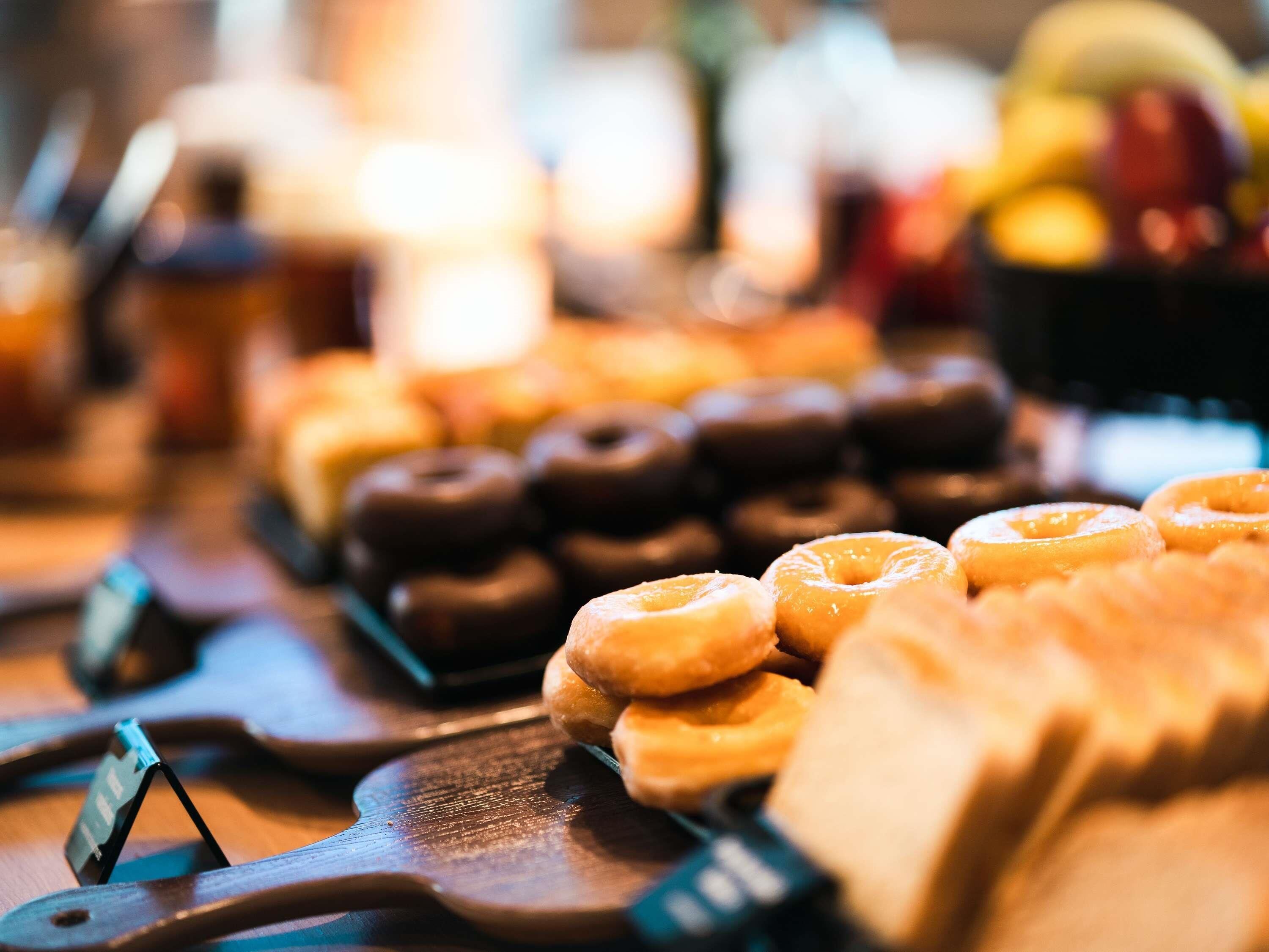 Variedad de donas expuestas en bandejas de madera.