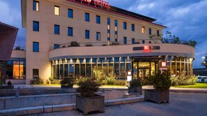 A modern hotel with a prominent 'ibis Hotel' sign, a glass facade, and a landscaped entrance area. - ibis Valladolid (Valladolid)