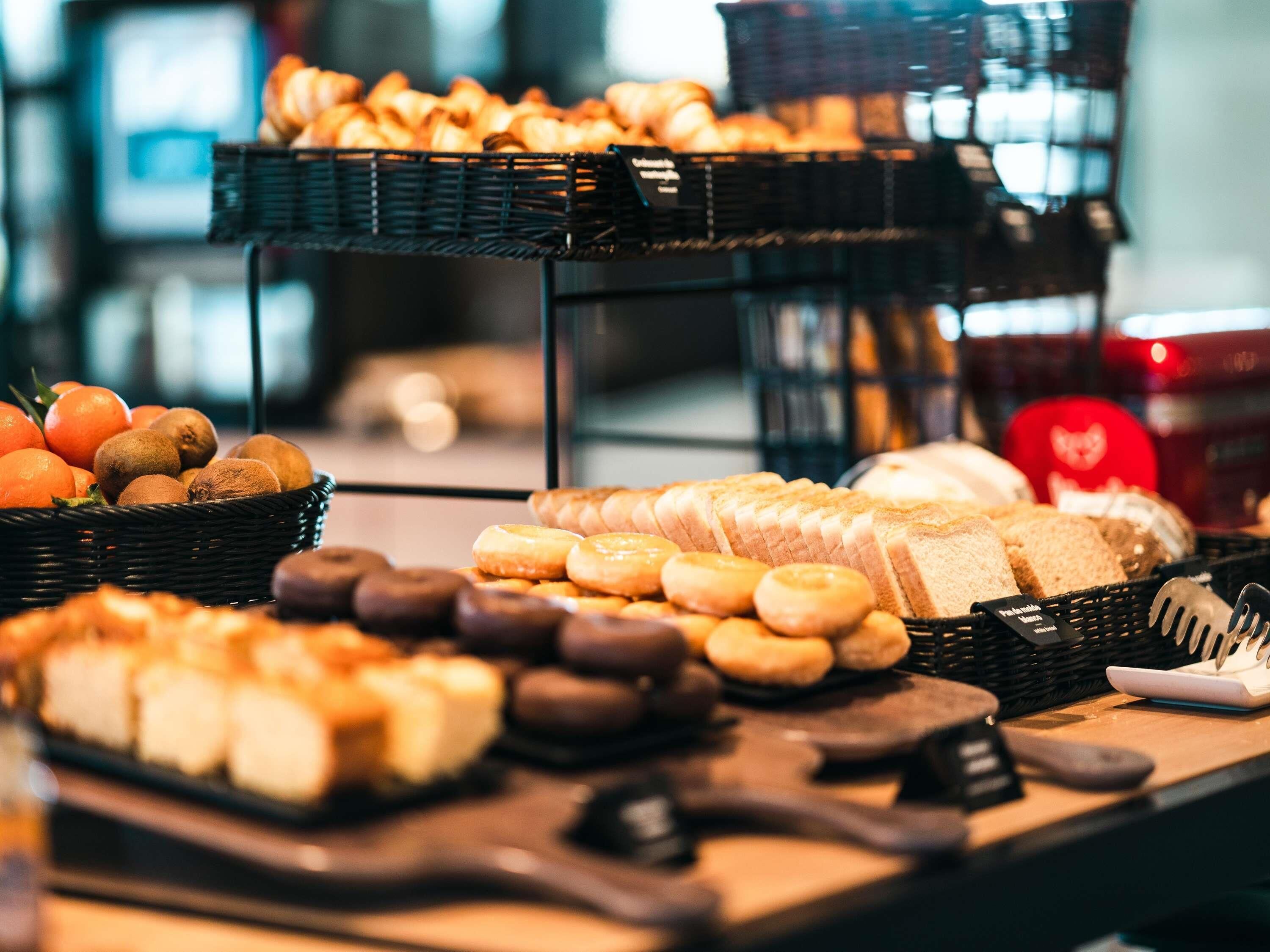 A buffet with various baked goods and fruits.