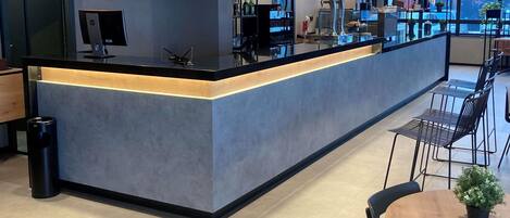 A modern bar area with a counter, seating, and a view of the outside.