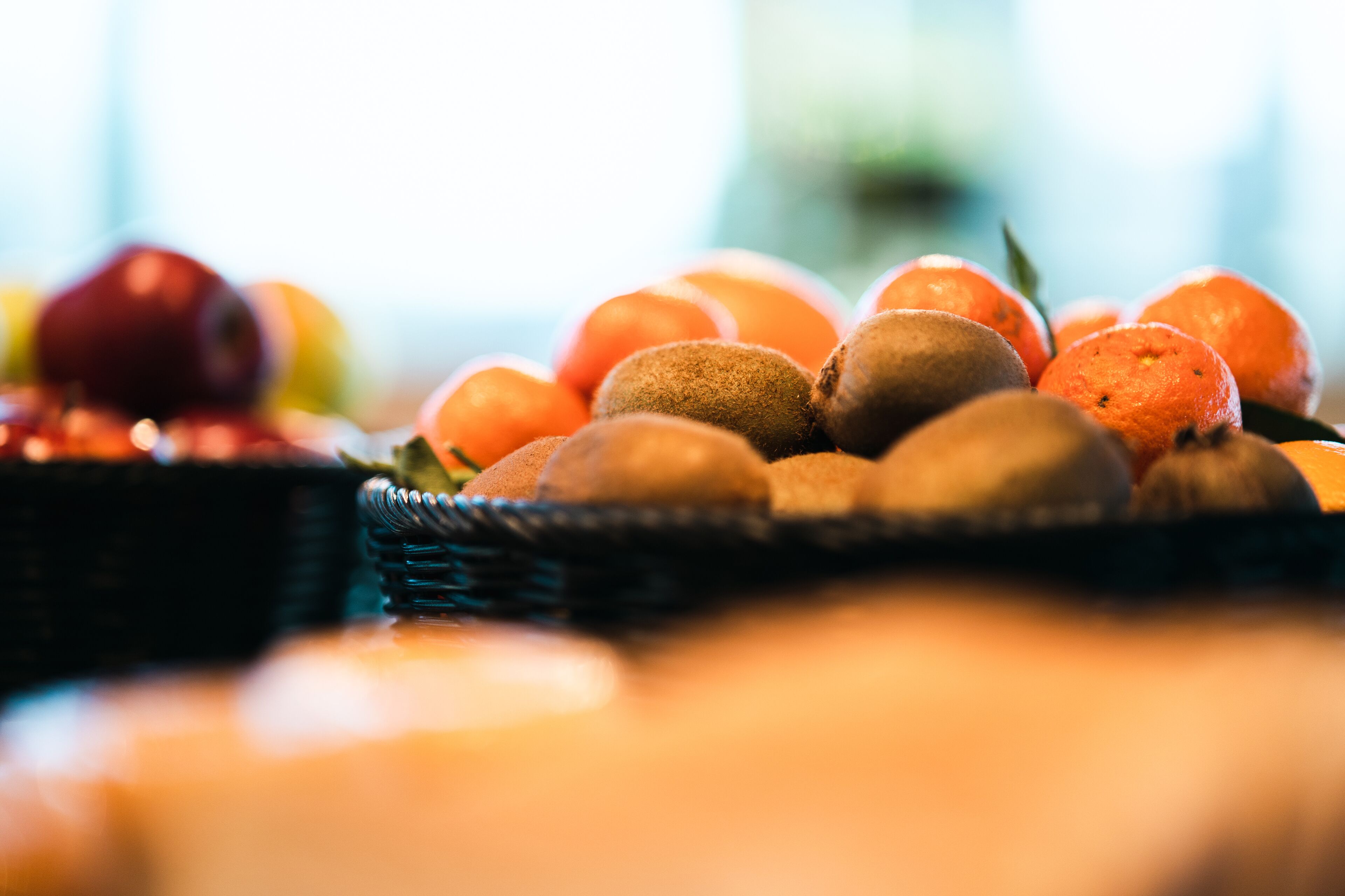 A close-up of a fruit basket with oranges and kiwis.