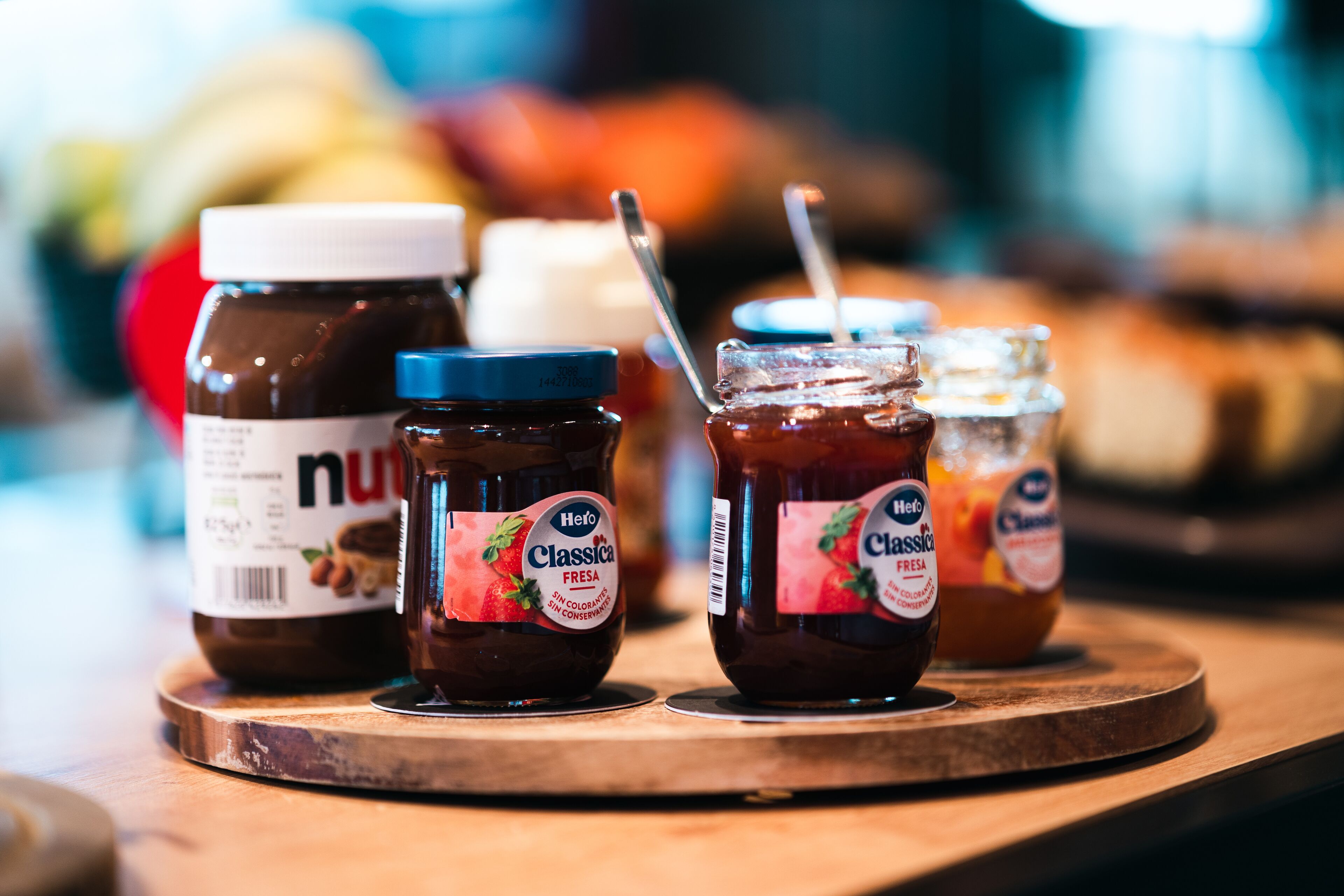 Three jars of jam on a wooden board.
