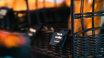 A wicker basket with a tag labeled "Pan de semillas" (Seed bread).