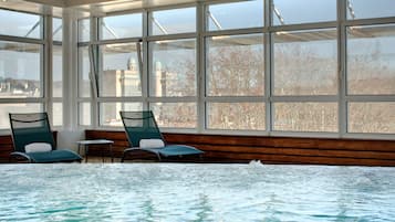 Una piscina cubierta, una piscina al aire libre, sombrillas, tumbonas