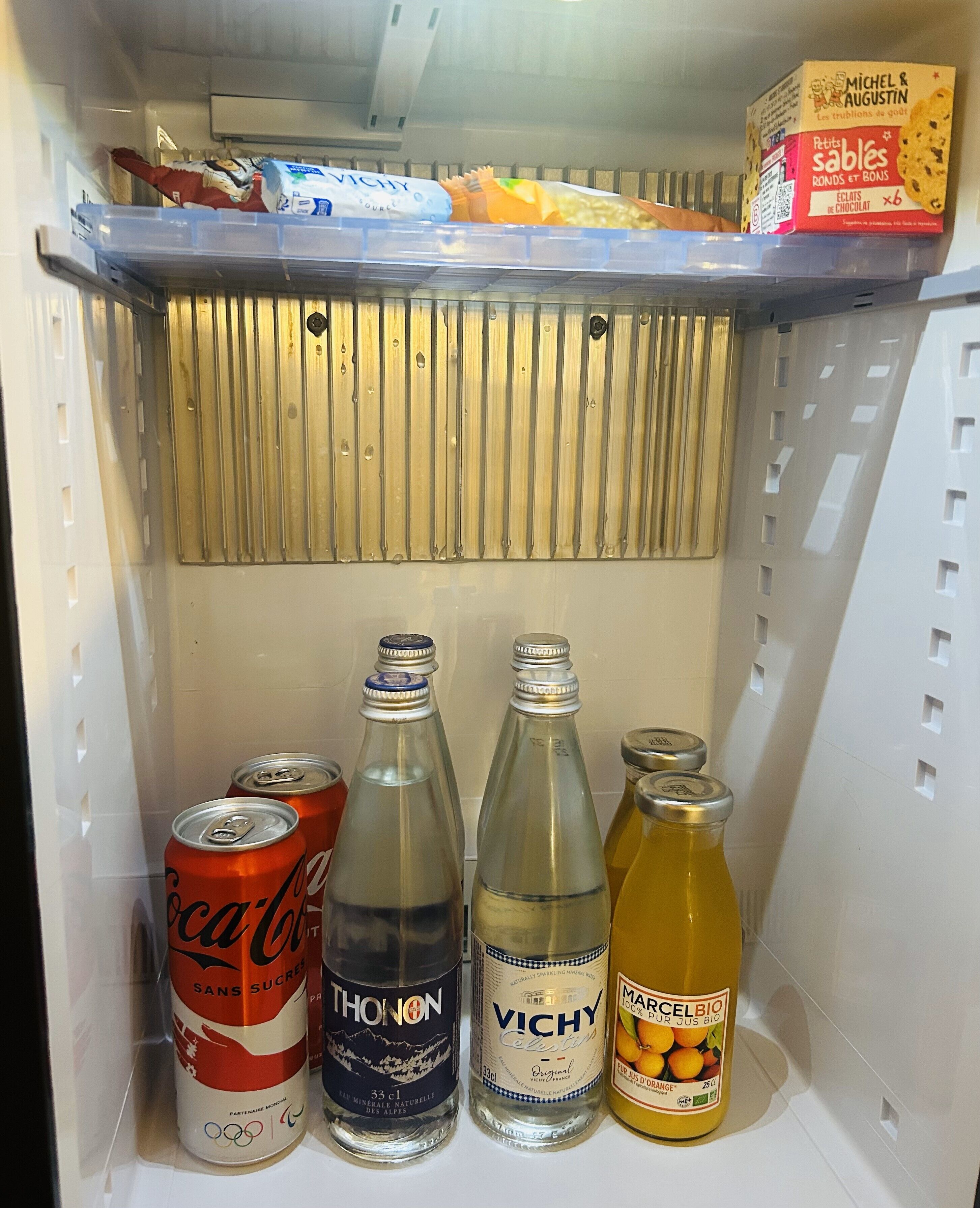 A refrigerator with beverages and snacks.