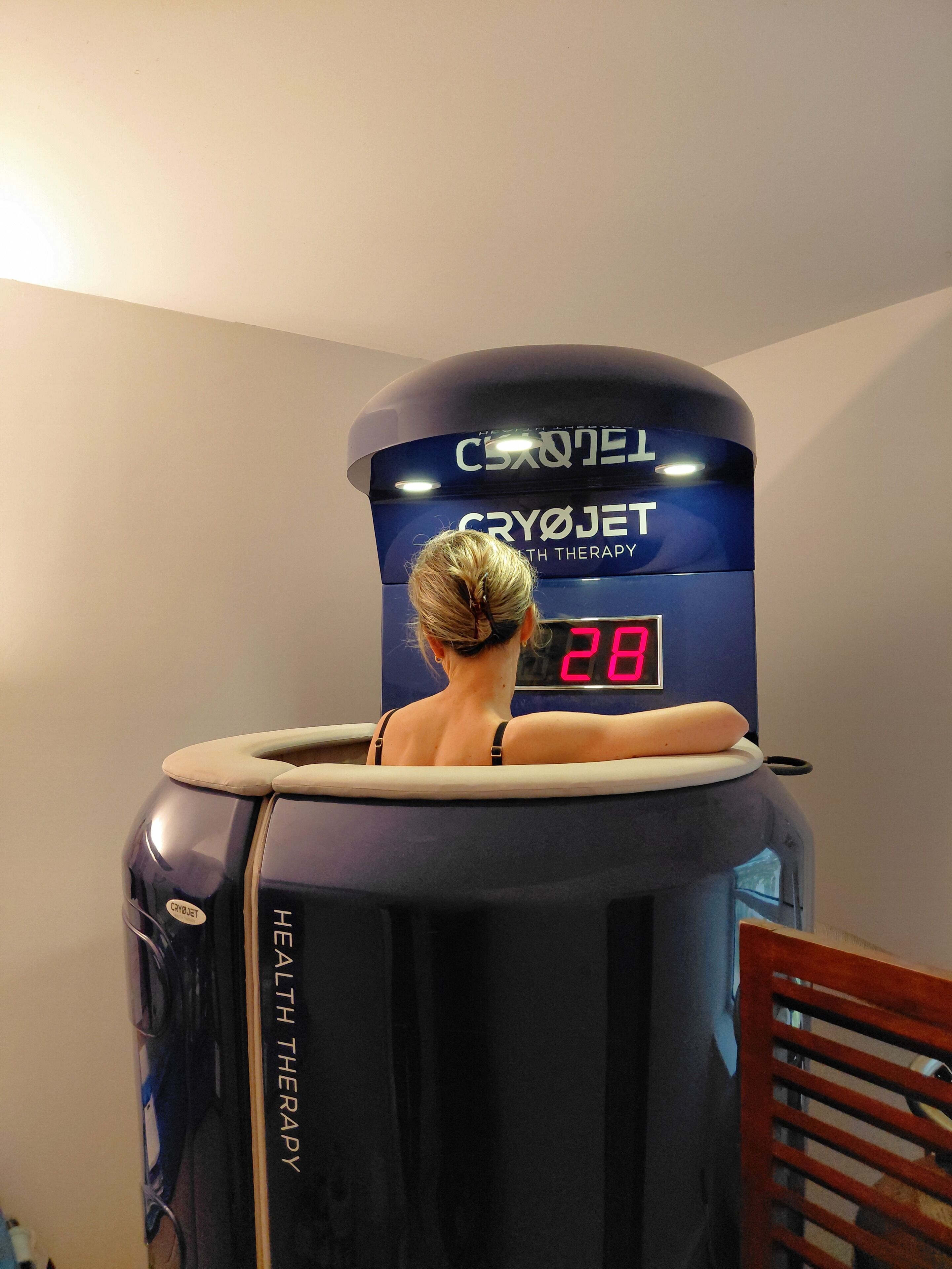 A cryotherapy chamber with a digital display reading '28' and the text 'CRYOTREATMENT WITH THERAPY' on the front.