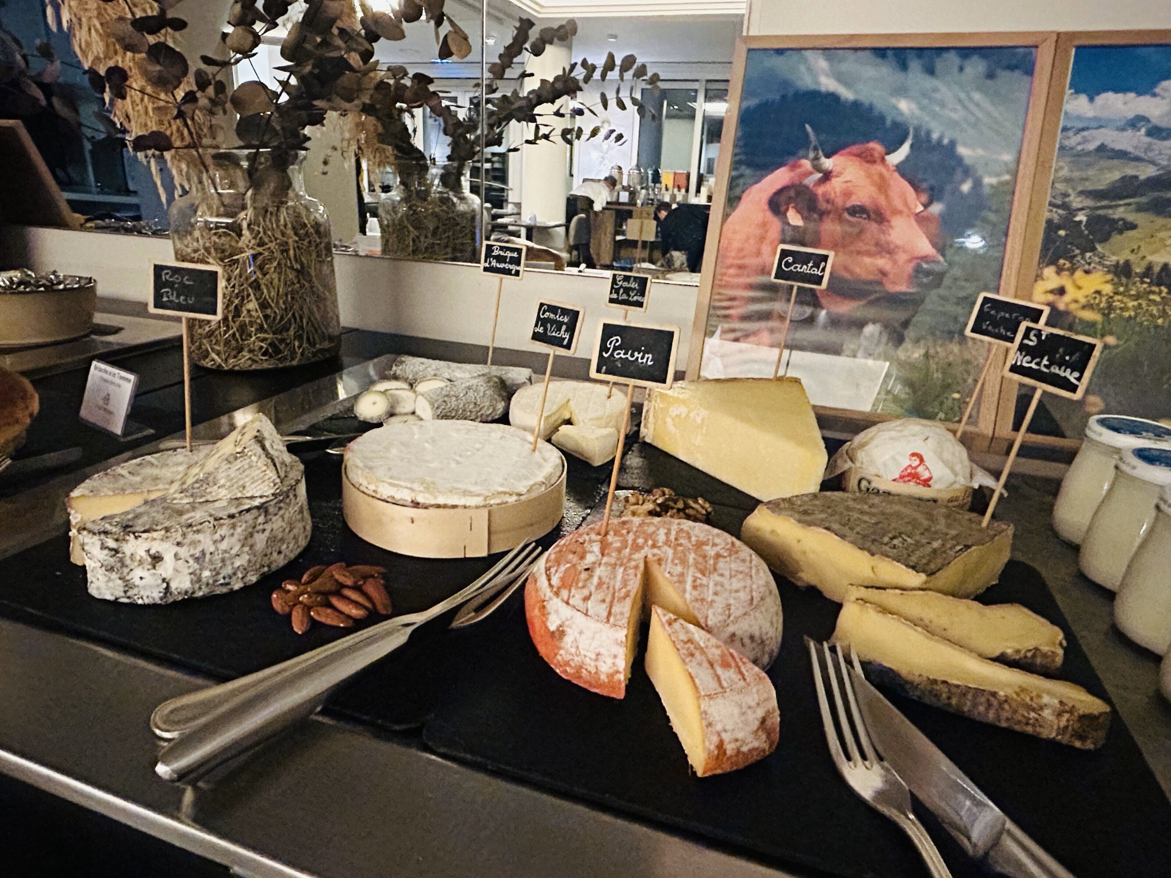 A cheese display with various types of cheese and labels indicating names like 'Roc' and 'Pavin.'