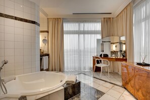 A modern bathroom with a large bathtub, a vanity with a mirror, and a shower area. - Célestins Spa Thermal & Hôtel (Vichy)