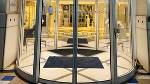 The entrance to Vichy Celestins Spa Hotel with a glass revolving door and a sign above.