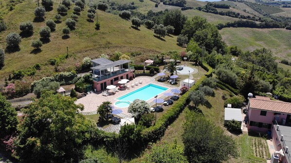 Relax by the central pool surrounded by lush gardens and sun loungers.