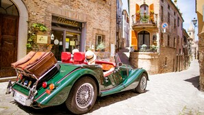 A vintage green convertible parked on a cobblestone street. - I Calanchi Country Hotel & Resort (Ripatransone)