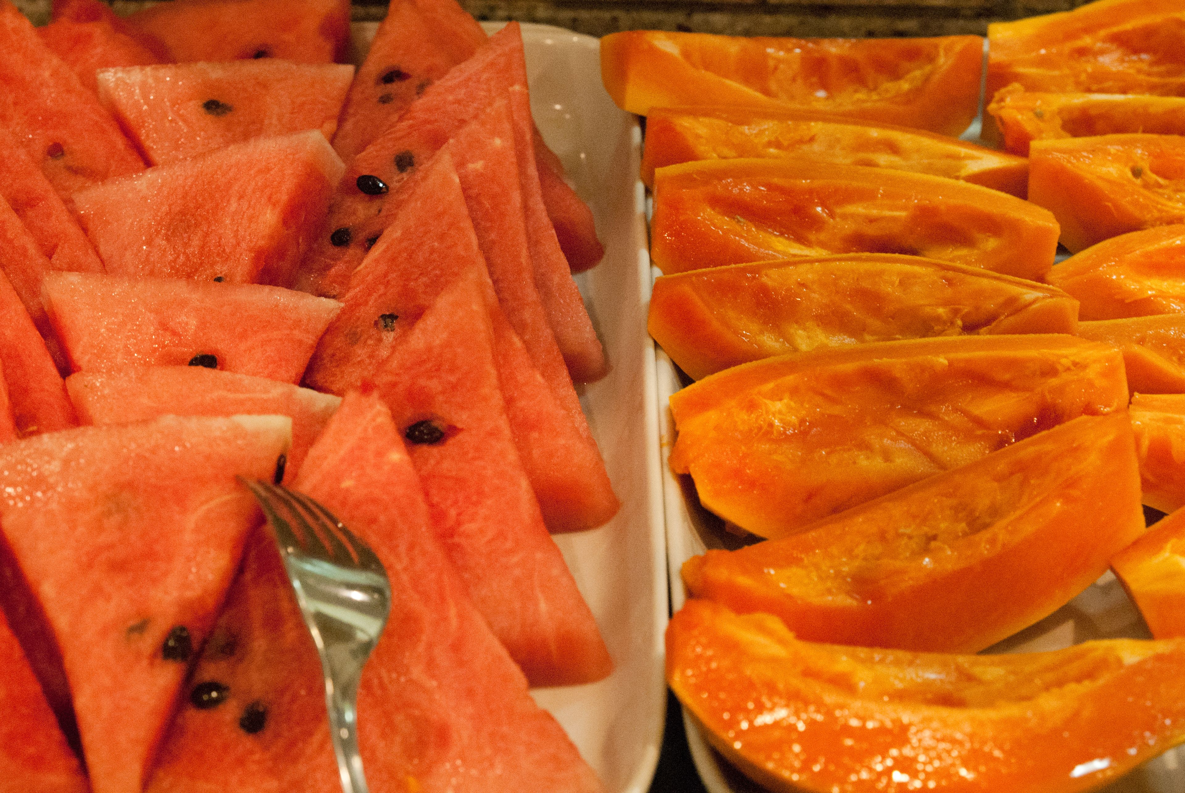 A tray of sliced fruits including watermelon and papaya.