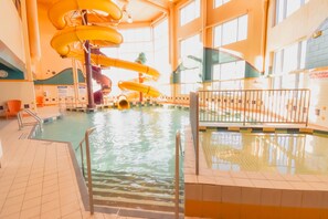 An indoor swimming pool with multiple slides and a tiled floor. - Canad Inns Destination Centre Polo Park (Winnipeg)