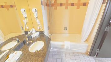 A bathroom with two sinks, a bathtub, and a shower.