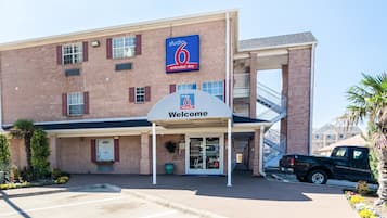 Welcome to Studio 6 Extended Stay, where guests can enjoy a convenient entrance and parking area surrounded by a small garden.