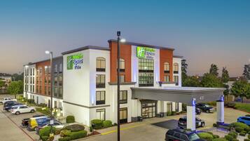 Een Holiday Inn Express gebouw met een parkeerplaats en een overdekte doorgang.