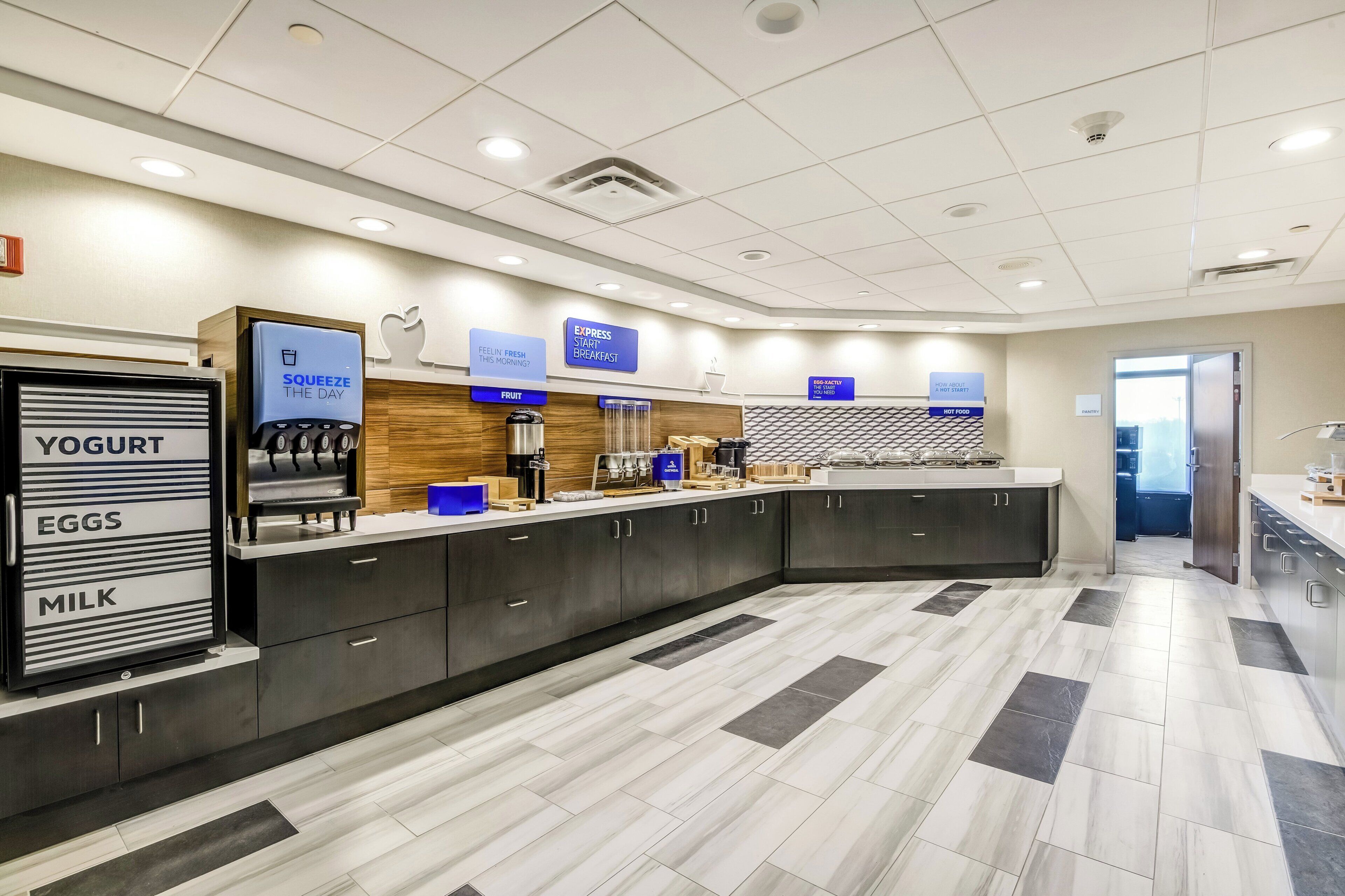 A modern kitchen area with a self-serve station for yogurt, eggs, and milk.