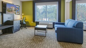 A modern room with a desk, chair, sofa, and large windows. - Holiday Inn Express & Suites Longview North by IHG (Longview)