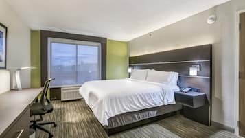 Habitación de hotel con cama, escritorio, silla y ventana con vistas.