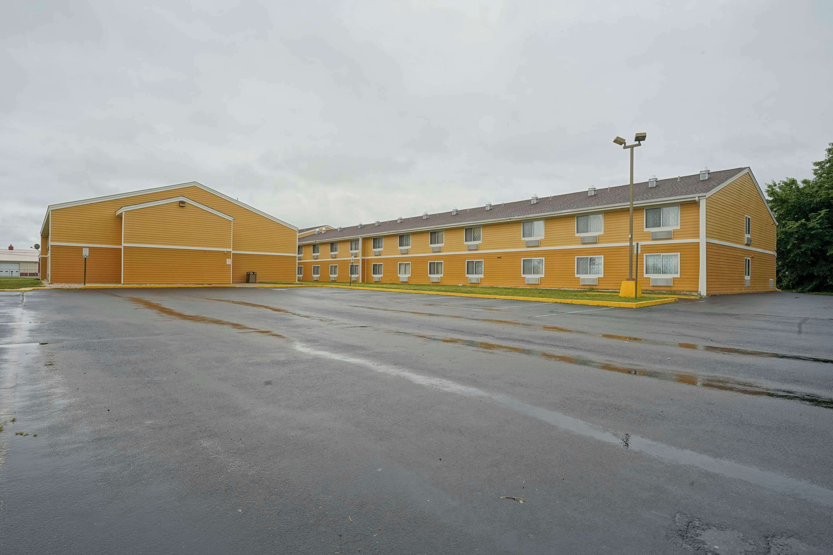 A large, yellow building with multiple windows and a flat roof.