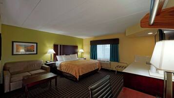 Una habitación de hotel con cama, sofá, escritorio y silla.