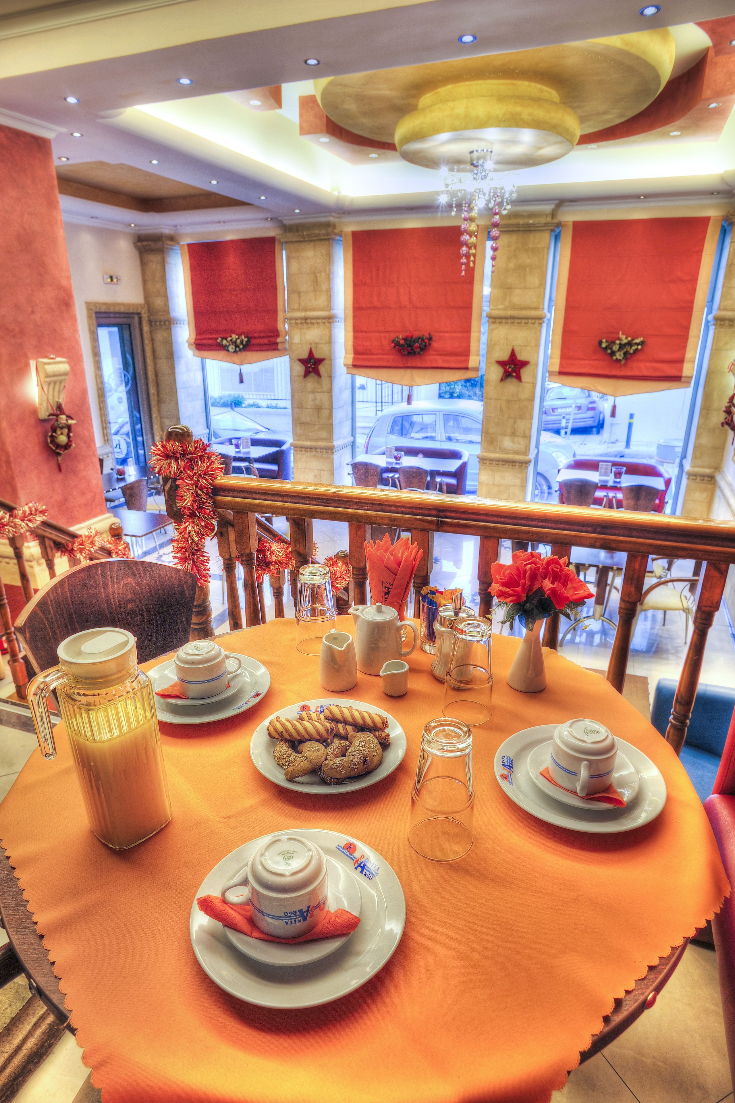 Un coin repas avec une table mise pour quatre personnes, comprenant des assiettes, des tasses et un pichet.