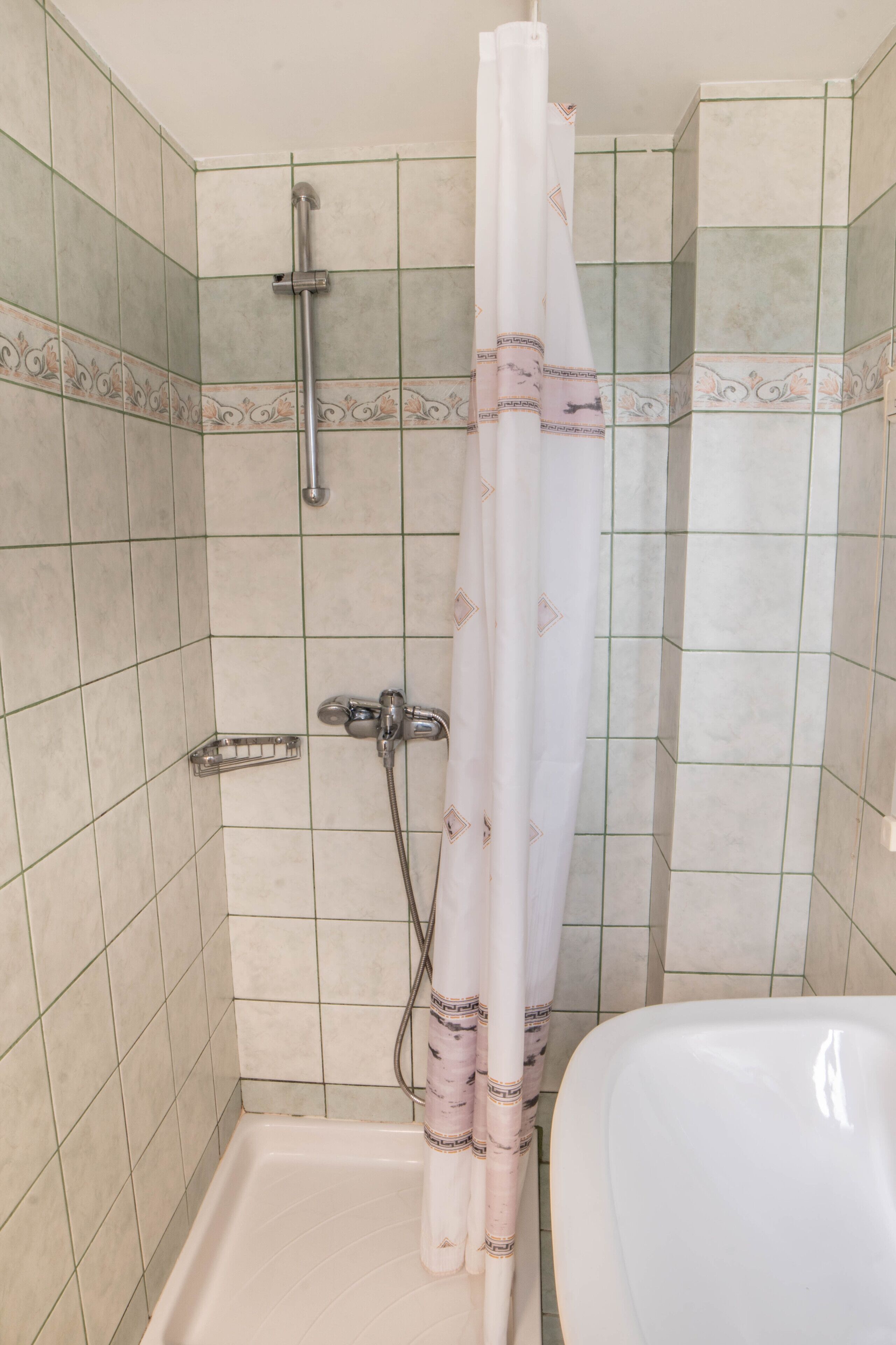 A bathroom with a shower, a toilet, and a bathtub.