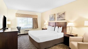 A hotel room with a large bed, a desk, a chair, a TV, and two bedside lamps. - Best Western Nebraska City Inn (Nebraska City)