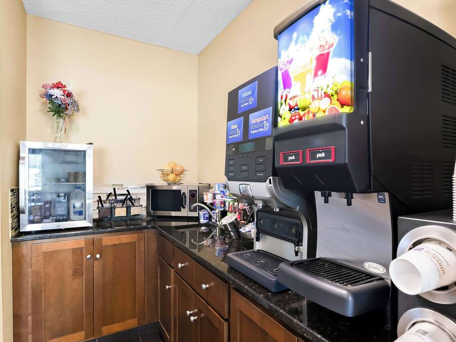 A kitchen with a coffee machine, a microwave, and a refrigerator.