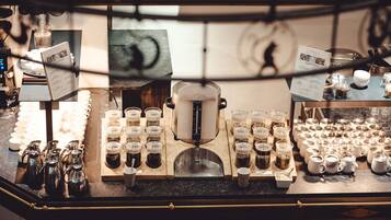 A coffee station with multiple brewing stations, coffee dispensers, and a variety of coffee containers.