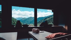 A room with a bed, a chair, and a window offering a mountain view. - Berghotel Rehlegg (Ramsau bei Berchtesgaden)