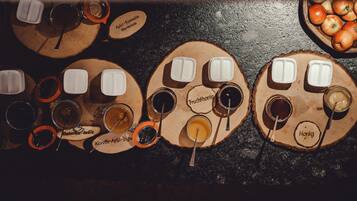 Una mesa de madera con varios recipientes de comida y bebidas, cada uno etiquetado con diferentes nombres.