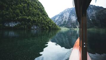 Une vue depuis un bateau sur un lac paisible, entouré de montagnes boisées.