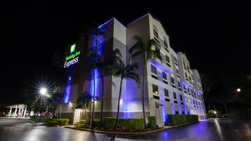 A Holiday Inn Express hotel with a modern design, featuring a prominent sign and illuminated facade.
